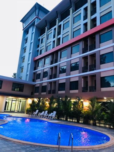 a large building with a large swimming pool in front of it at ATK Garden Hills in Hat Yai