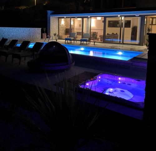 a swimming pool with a hot tub in the dark at Villa Carisma island Vis in Vis