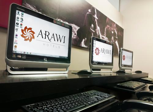 a desk with two computer monitors and a keyboard at Arawi Miraflores Prime in Lima