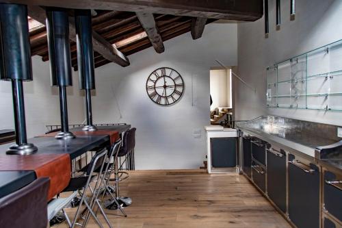 a kitchen with a counter and a clock on the wall at B&B Residenza San Giorgio in LʼAquila