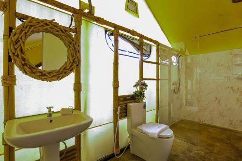 La salle de bains est pourvue d'un lavabo, de toilettes et d'un miroir. dans l'établissement Mont Blanc Glamping Khao Yai, à Mu Si