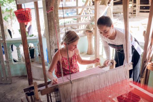 a woman and a little girl working on a machine at Mai Chau Ecolodge in Mai Chau