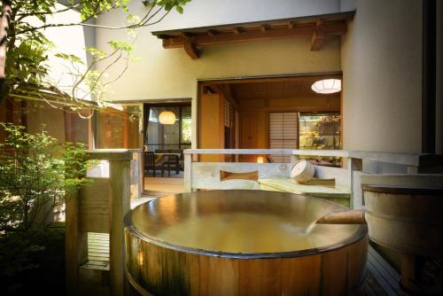 a wooden tub sitting outside of a house at Shouhakutei Azumaso in Tendo