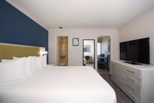 a bedroom with a large white bed and a television at SureStay Hotel by Best Western Santa Monica in Los Angeles
