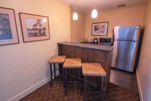 a kitchen with a bar with a refrigerator and stools at The Water Tower Inn - BW Premier Collection in Sault Ste. Marie