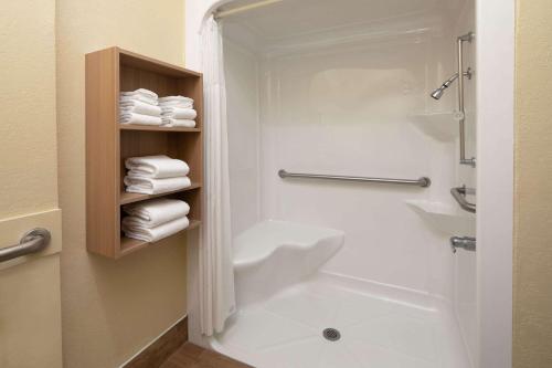 a bathroom with a shower and a toilet and towels at Microtel Inn & Suites by Wyndham Florence in Florence