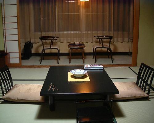 a black table with chairs and a bowl on it at Shouhakutei Azumaso in Tendo