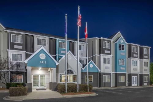 a hotel with two flags in front of a building at Microtel Inn & Suites by Wyndham Florence in Florence