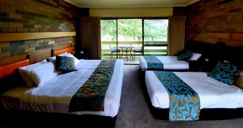 a hotel room with two beds and a table at Shepparton Golf Motel in Shepparton