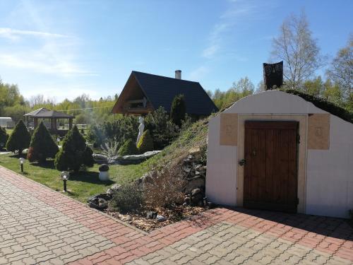 a small building with a door in a yard at Rähni Guesthouse Lake Peipsi in Vilusi