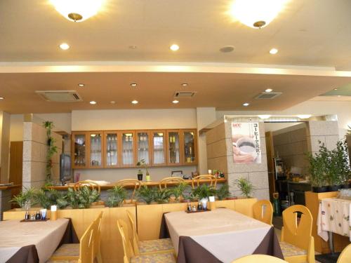 a restaurant with two tables and chairs in a room at Hotel Benex Yonezawa in Yonezawa