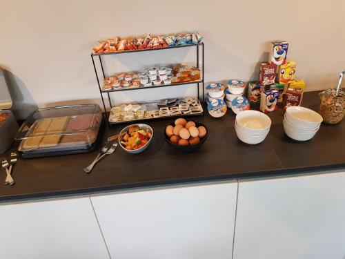 a counter with bowls of eggs and other food on it at B&B de Wilhelminaschool in Aalten