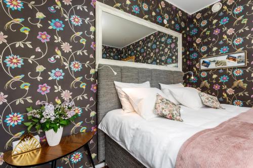1 dormitorio con 1 cama, espejo y flores en Villa Aia Studio, en Pärnu