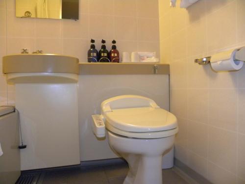a bathroom with a white toilet and a sink at Hotel Benex Yonezawa in Yonezawa