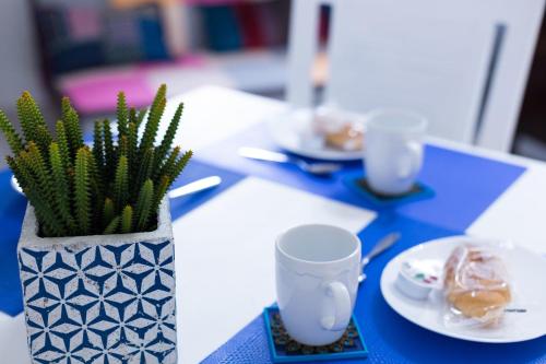 einem blauen Tisch mit einer Vase mit einer Pflanze darauf in der Unterkunft MiKlod Apartments in Palermo