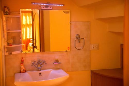 a bathroom with a sink and a mirror at AMBIKA HOME STAY in Solan