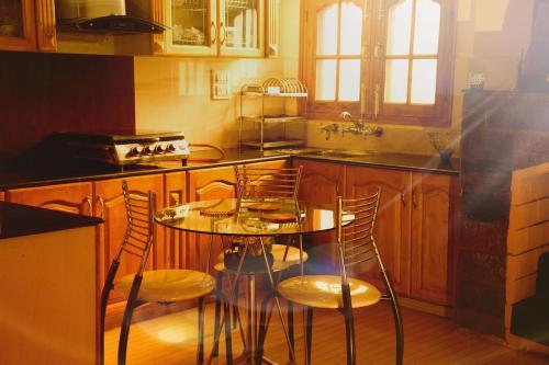 een keuken met een tafel en stoelen bij AMBIKA HOME STAY in Solan