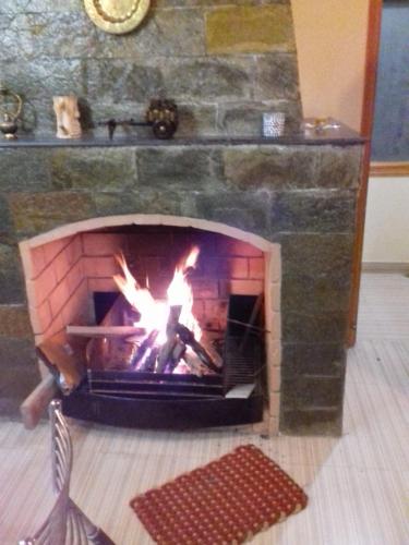 a brick fireplace with a fire in it at AMBIKA HOME STAY in Solan