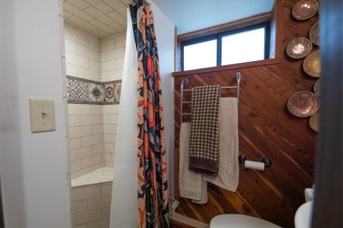 La salle de bains est pourvue d'une douche, de toilettes et d'une fenêtre. dans l'établissement Guest Suite at The Red House basement attached with private entrance, à Salt Lake City