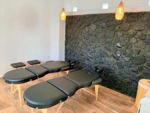 a waiting room with leather chairs and a stone wall at San Marino Suites by Calm Collection in Fira