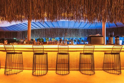 a bar with four bar stools in front of a counter at Orka Cove Hotel Penthouse & Suites Adults Only in Fethiye