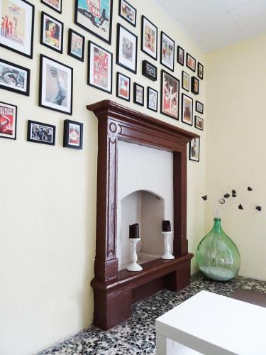 a living room with a fireplace and a wall of pictures at Villa Albonico in Laglio