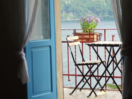 a door leading to a balcony with a table and chairs at Villa Albonico in Laglio