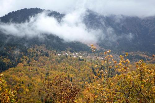 a view of a mountain with clouds and trees at Levanta in Méga Khoríon