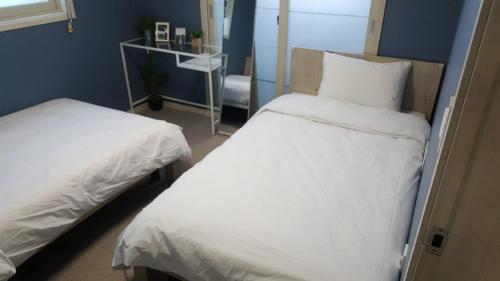 a bedroom with two beds and a blue wall at It's W in Suwon
