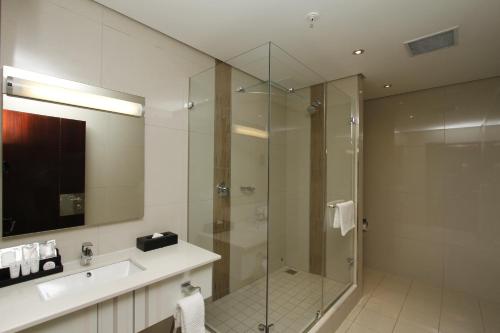 a bathroom with a glass shower and a sink at Coastlands Umhlanga Hotel and Convention Centre in Durban