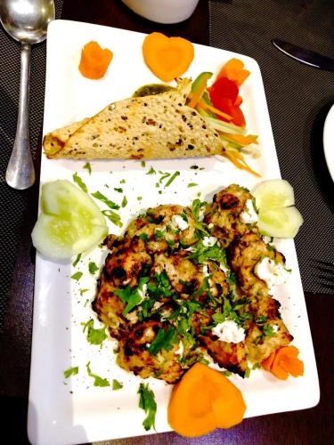 Un plato blanco con comida sobre una mesa. en Buddha Imperial, en Muzaffarpur