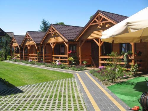 a log cabin with a walkway in front of it at Domki w Ogrodzie in Stegna