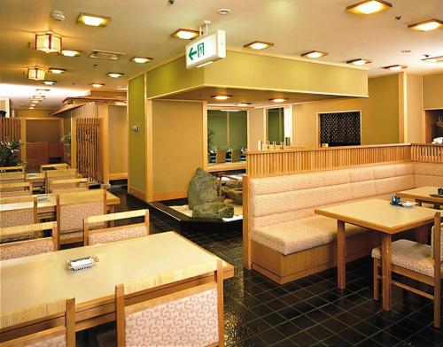 a restaurant with tables and chairs and a waiting room at Fukuyama New Castle Hotel in Fukuyama
