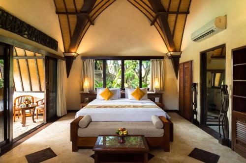 een slaapkamer met een groot bed in een kamer bij Hotel Vila Lumbung in Seminyak