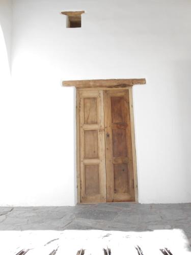a wooden door in a white building with a roof at Hosteria Villa Cardon in Cachí