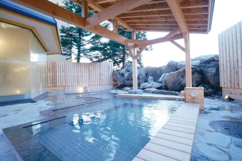 einen Pool in einem Haus mit Holzdach in der Unterkunft Tazawako Lake Resort & Onsen in Senboku