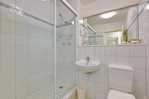 a bathroom with a shower and a toilet and a sink at Burnie Central Townhouse Hotel in Burnie