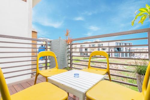 a balcony with two yellow chairs and a table at Seaway in Magong