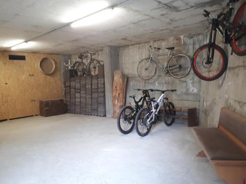 due biciclette appese al muro di un garage di Casa ai Ross a Valdisotto