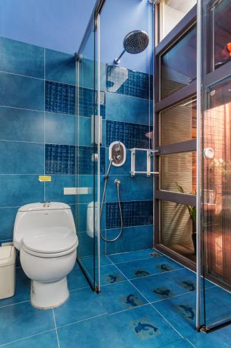 a blue bathroom with a toilet and a shower at Seaway in Magong