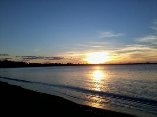 a sunset on the beach with the sun setting at Seaforth Holiday Units in Seaforth