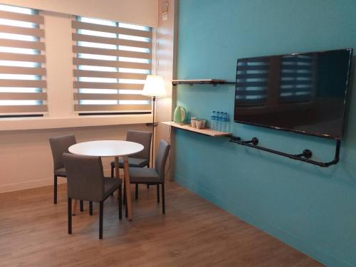 Camera con tavolo, sedie e TV a schermo piatto. di Next door of No 7 Youheng B&B a Città di Hualien