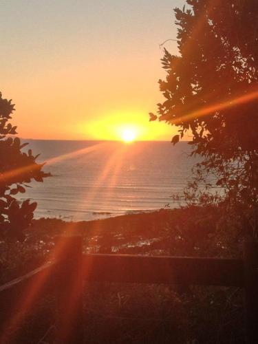 a sunset over the ocean with the sun setting at Seaforth Holiday Units in Seaforth