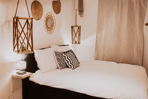 博倫多夫的住宿－Holiday Home Leonie，一间卧室配有带白色床单和枕头的床。