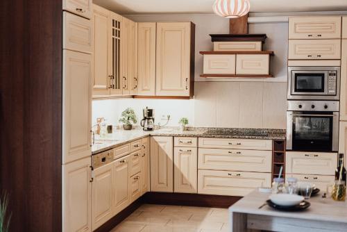 a white kitchen with white cabinets and appliances at Holiday Home Leonie in Bollendorf