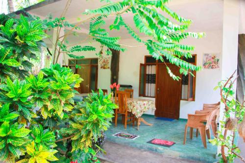a room with a table and chairs and plants at Amba Sewana Homestay in Sigiriya