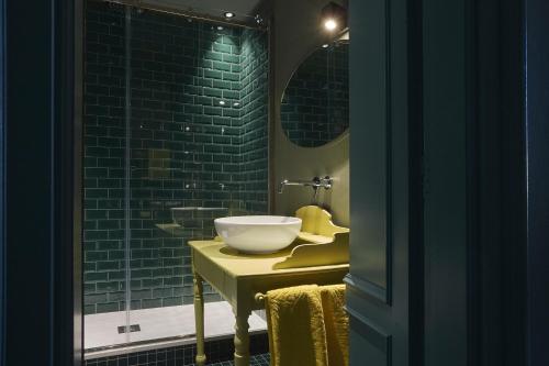 a bathroom with a bowl sink on a yellow table at Look To in Turin