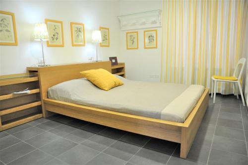 ein Schlafzimmer mit einem Bett mit einem gelben Kissen darauf in der Unterkunft La Palma vacanze in riva al mare in Diano Marina
