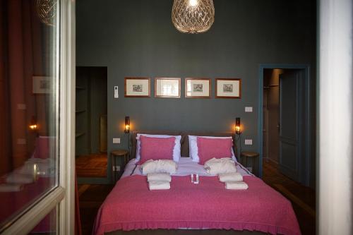 a bedroom with a pink bed with towels on it at Look To in Turin