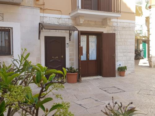 un edificio con una porta marrone e alcune piante di B&B Gallina 18 a Bari
